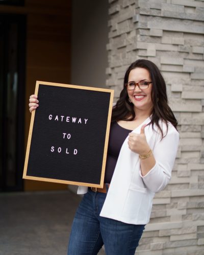 Jaydee Sheppard holding a gateway to sold sign